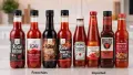Bottles of NZ-made sugar-free keto sauces on a kitchen bench next to imported alternatives
